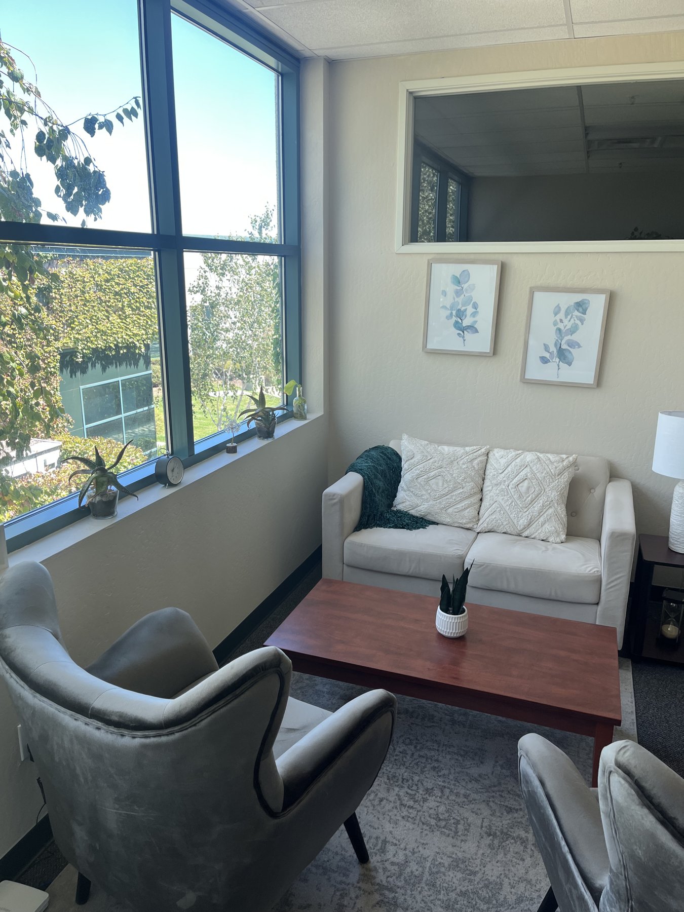 Our therapy room with large windows and a cream sofa