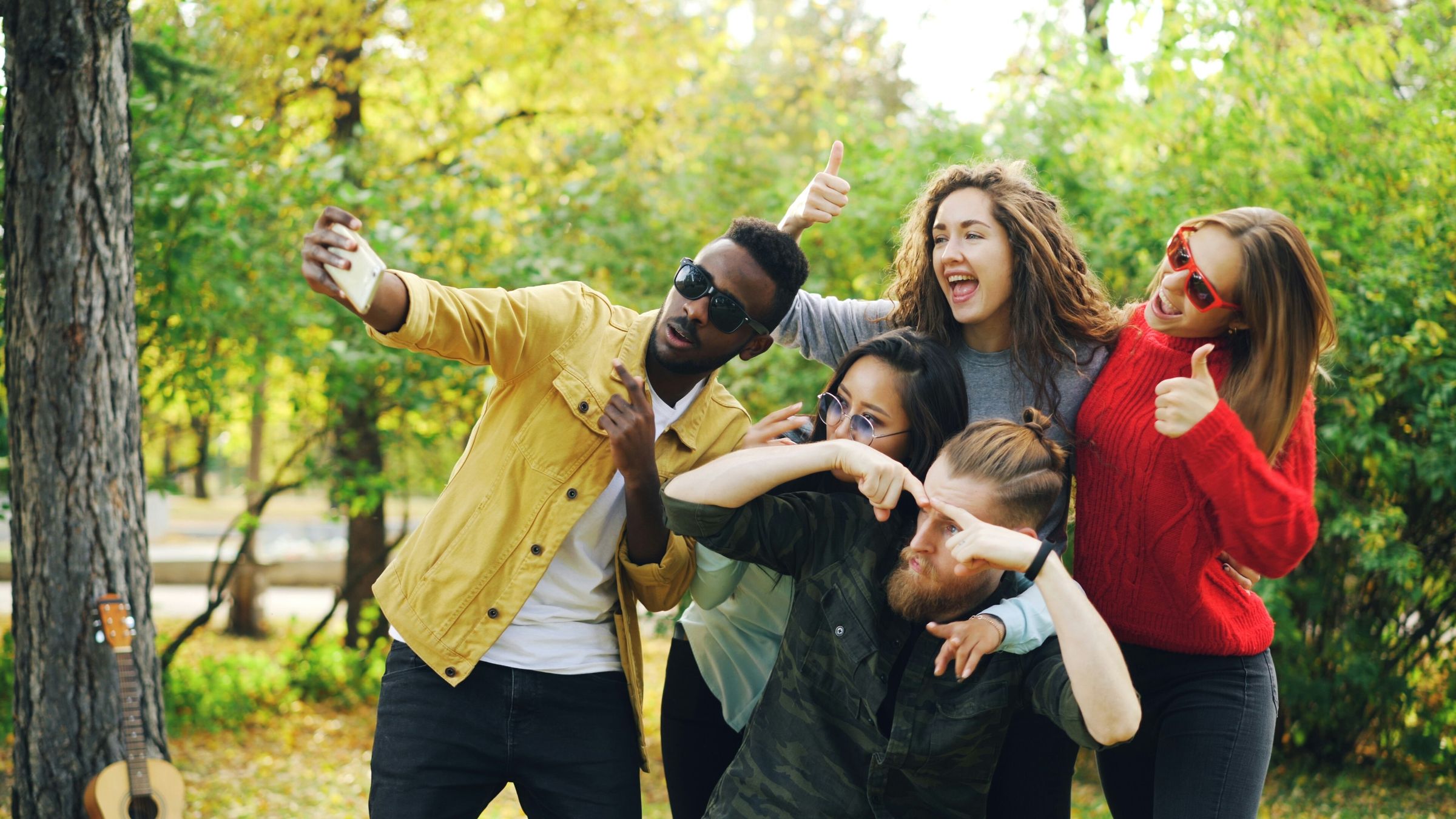 Friends taking a selfie together in a sunny park